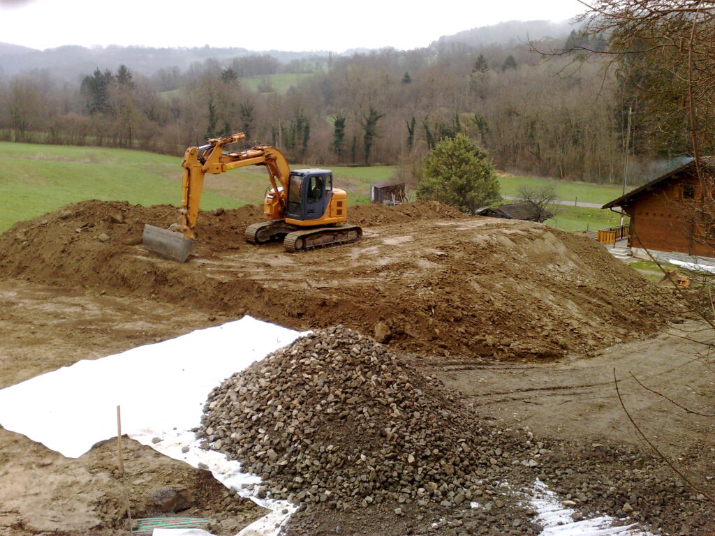 Terrassement d’un terrain en pente avec pelle chenille.