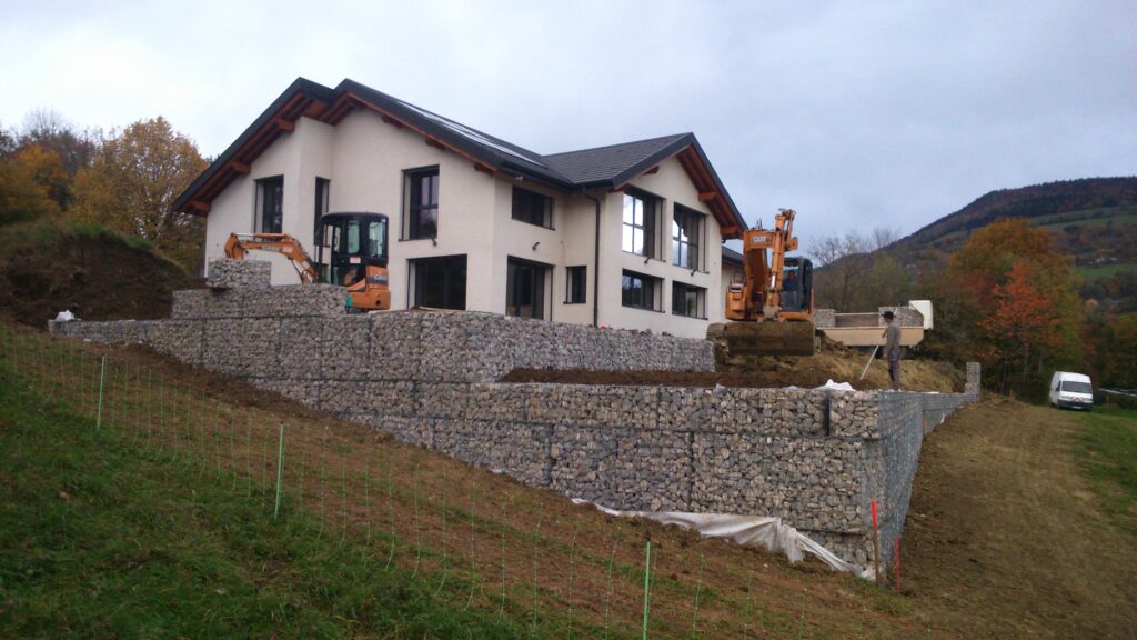 Mur de gabions pour soutènement autour d’une maison en terrain pentu.