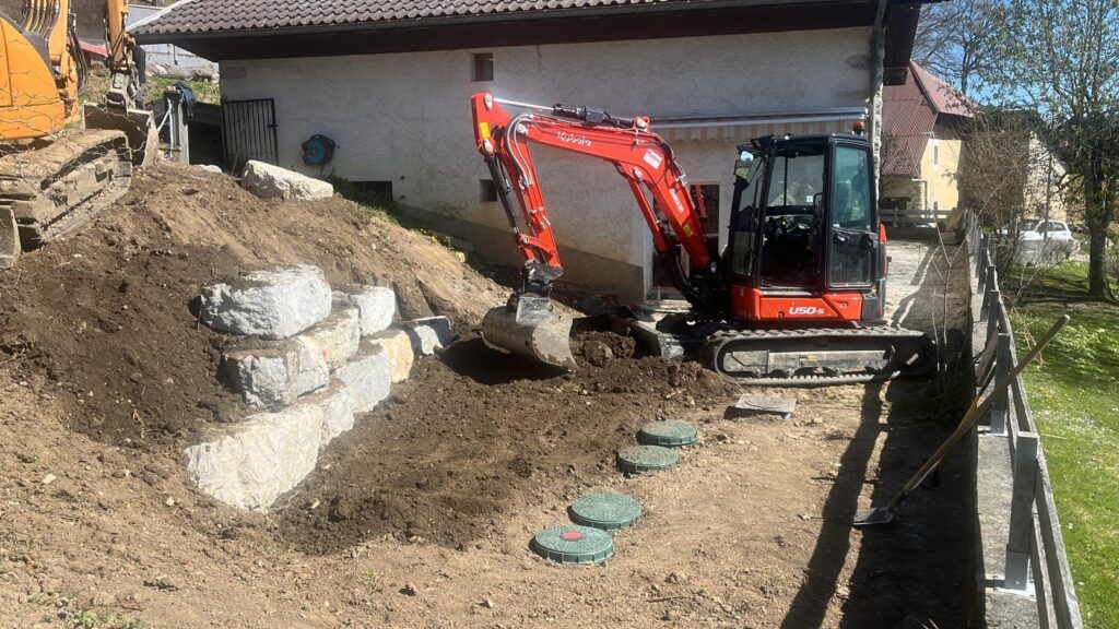 Travaux d’assainissement avec mini-pelle sur chantier résidentiel.