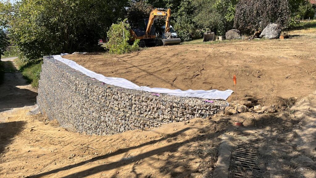 Mur de gabions courbé réalisé à la main pour suivre la forme du virage.