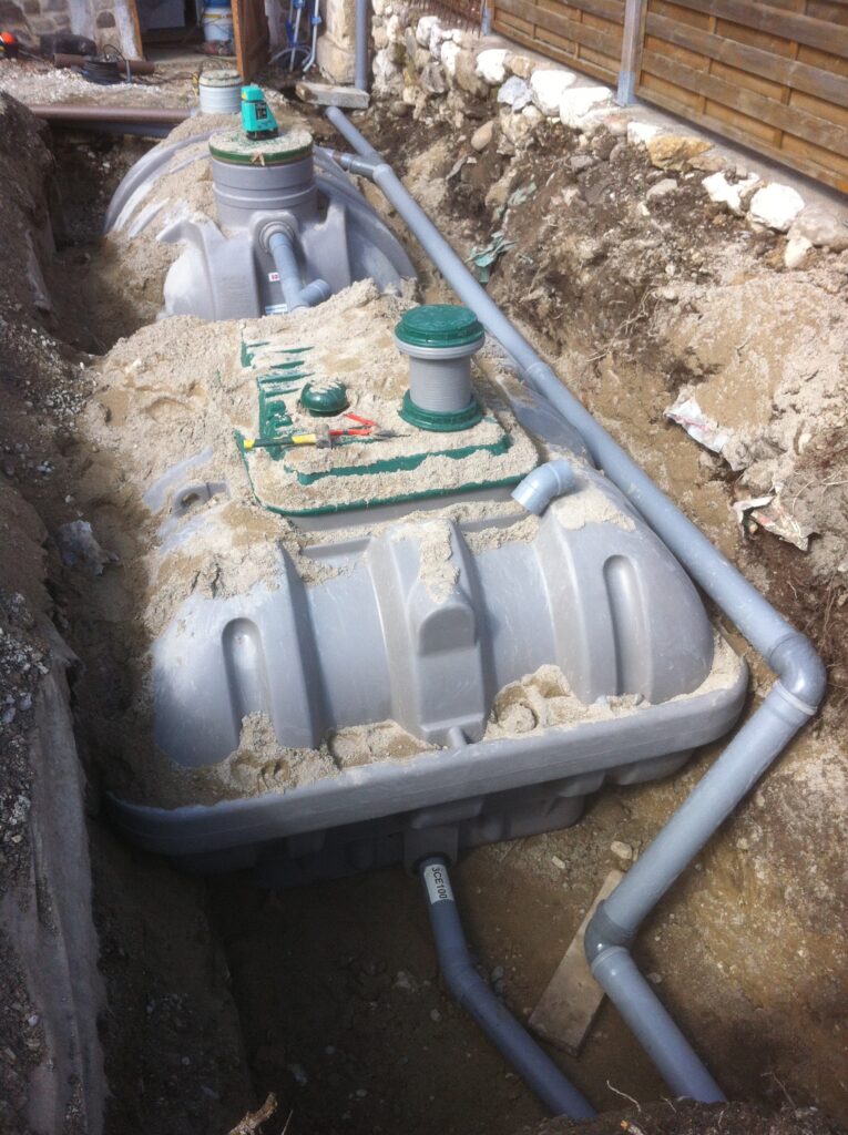 Installation d’une cuve d’assainissement enterrée avec raccordements.